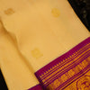 A close-up of a Cream silk saree body with subtle woven motifs, featuring a rich magenta and gold zari border.