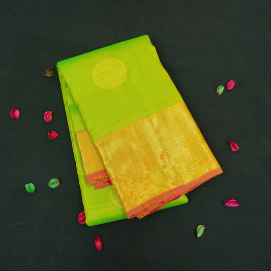 Parrot green Kanchipuram silk saree with pink orange zari border and gold buttas, traditional pattu saree for wedding wear.