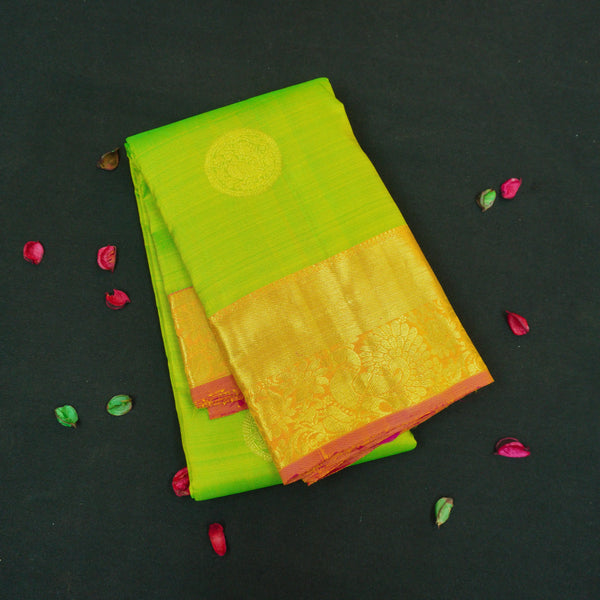 Parrot green Kanchipuram silk saree with pink orange zari border and gold buttas, traditional pattu saree for wedding wear.