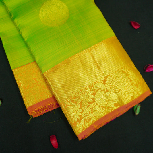 Parrot green Kanchipuram silk saree with pink orange zari border and gold buttas, traditional pattu saree for wedding wear.