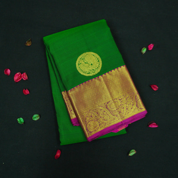 Bottle green Kanchipuram silk saree with magenta border, rich gold zari pallu, and round zari motifs – traditional South Indian wedding saree from Vivaaha Silks.