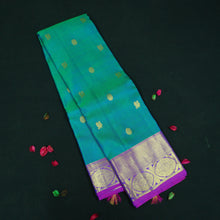 Load image into Gallery viewer, Peacock blue Kanchipuram silk saree with violet border, gold zari peacock and chakaram butta, and rich woven pallu – traditional bridal saree by Vivaaha Silks.