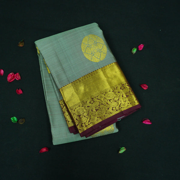Grey Kanchipuram silk saree with gold zari chakaram butta, rich orange-gold pallu, and brown floral border – traditional wedding silk saree from Vivaaha Silks.