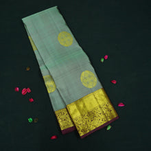 Load image into Gallery viewer, Grey Kanchipuram silk saree with gold zari chakaram butta, rich orange-gold pallu, and brown floral border – traditional wedding silk saree from Vivaaha Silks.