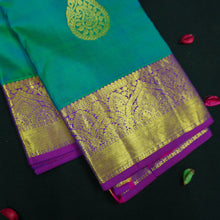 Load image into Gallery viewer, Peacock blue Kanchipuram silk saree with gold zari thilagam butta motifs, violet border, and rich woven pallu – traditional bridal silk saree by Vivaaha Silks.