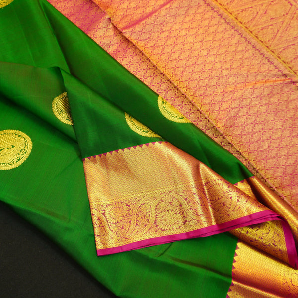 Bottle green Kanchipuram silk saree with magenta border, rich gold zari pallu, and round zari motifs – traditional South Indian wedding saree from Vivaaha Silks.