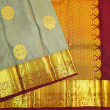 Load image into Gallery viewer, Grey Kanchipuram silk saree with gold zari chakaram butta, rich orange-gold pallu, and brown floral border – traditional wedding silk saree from Vivaaha Silks.