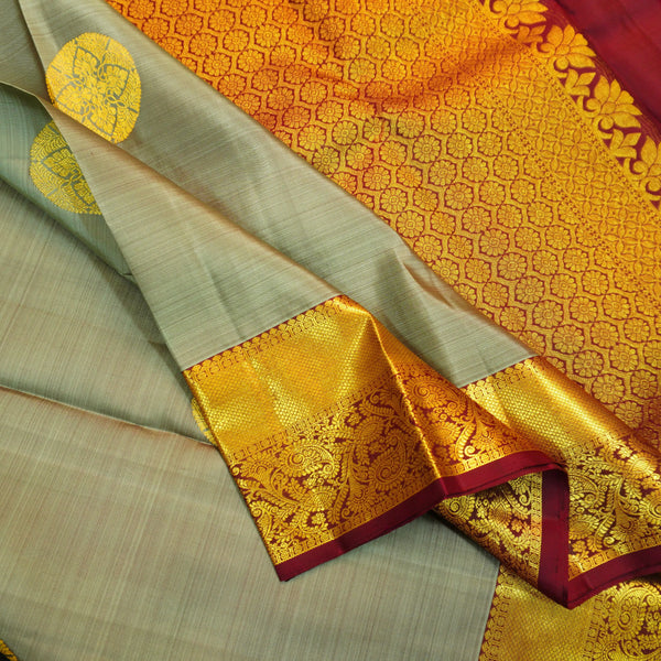 Grey Kanchipuram silk saree with gold zari chakaram butta, rich orange-gold pallu, and brown floral border – traditional wedding silk saree from Vivaaha Silks.