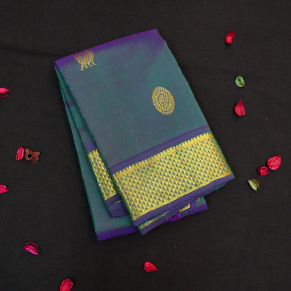 Peacock blue Kanchipuram silk saree from Vivaaha Silks budget collection featuring gold annam and chakaram butta, and a grand zari pallu with paisley and diamond motifs.