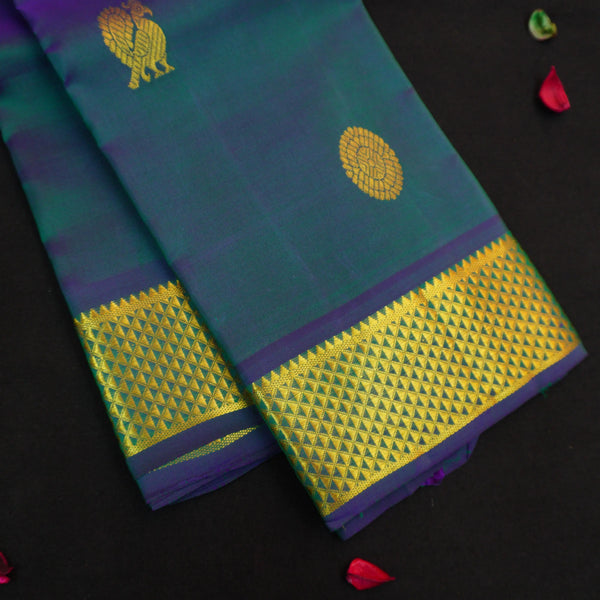 Peacock blue Kanchipuram silk saree from Vivaaha Silks budget collection featuring gold annam and chakaram butta, and a grand zari pallu with paisley and diamond motifs.
