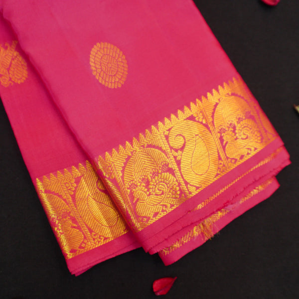 Peach pink Kanchipuram silk saree with gold annam and chakaram butta motifs, rich zari pallu, and traditional temple border – perfect for bridal and festive wear from Vivaaha Silks.