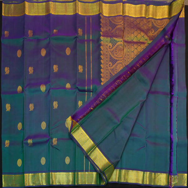 Peacock blue Kanchipuram silk saree from Vivaaha Silks budget collection featuring gold annam and chakaram butta, and a grand zari pallu with paisley and diamond motifs.