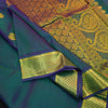 Peacock blue Kanchipuram silk saree from Vivaaha Silks budget collection featuring gold annam and chakaram butta, and a grand zari pallu with paisley and diamond motifs.