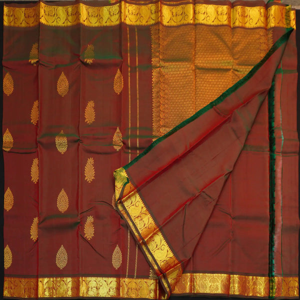 Manthulir short color Kanchipuram silk saree from Vivaaha Silks budget collection featuring golden thilagam buttas and rich zari pallu with traditional border.