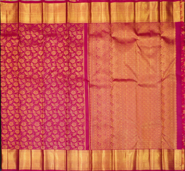 A close-up of a richly patterned silk saree, likely a Banarasi, featuring a magenta-pink body with intricate gold zari floral motifs on one side, a peach-pink body with delicate gold woven borders on the other, and a wide gold zari border at the top and bottom.