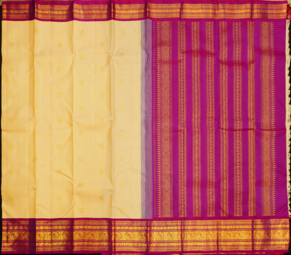 A close-up of a fabric textile laid flat, showing a cream-yellow body with small gold motifs and a wide magenta-purple border with gold woven detailing.