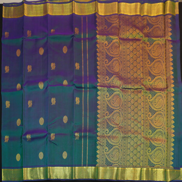 Peacock blue Kanchipuram silk saree from Vivaaha Silks budget collection featuring gold annam and chakaram butta, and a grand zari pallu with paisley and diamond motifs.