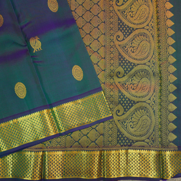 Peacock blue Kanchipuram silk saree from Vivaaha Silks budget collection featuring gold annam and chakaram butta, and a grand zari pallu with paisley and diamond motifs.